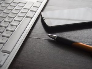 Egy billentyűzet, egy telefon és egy toll van egy asztalon. A kép illusztrációnak szólgál az elővásárlási jog kérdéseivel foglalkozó cikk számára.